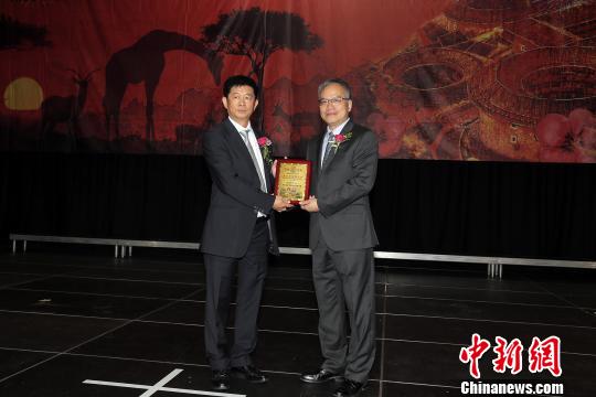 中国驻约堡副总领事屈伯勋(右)给第五届会长温耀滨颁发任职证书。　宋方灿 摄