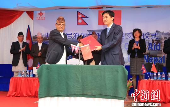 中国驻尼泊尔大使馆商务参赞彭伟和尼方代表签署项目交接证书。　张晨翼 摄
