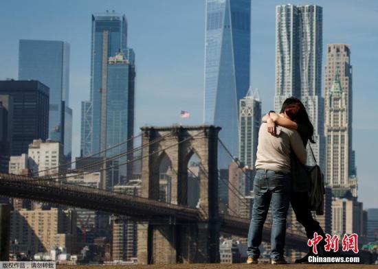 一对情侣相拥在布鲁克林大桥旁。