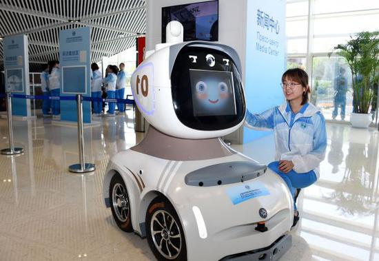 上合组织青岛峰会志愿者展示新闻中心机器人“海海”（李紫恒 摄）