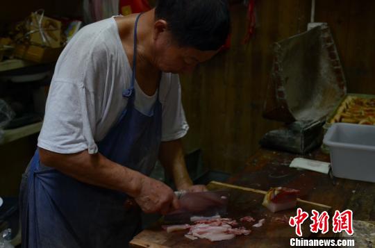 糕点作坊负责人程贵生切火腿肉，以制作火腿月饼的馅料 余皓 摄