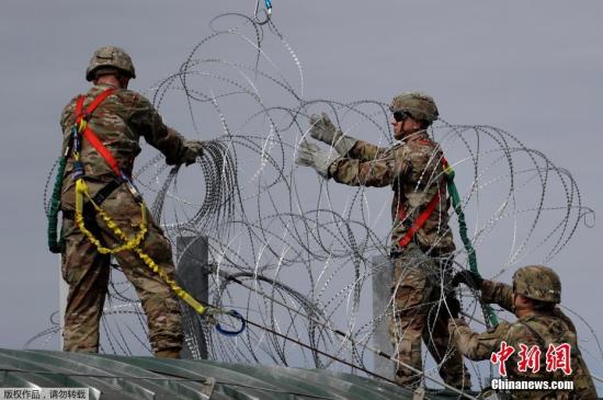 资料图：当地时间11月2日，美国得州Hidalgo，中美洲移民大军压境美国，美国士兵在美墨边境安装铁丝网严防移民入境。