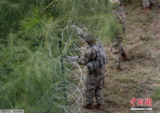 资料图：当地时间11月2日，美国得州Hidalgo，中美洲移民大军压境美国，美国士兵在美墨边境安装铁丝网严防移民入境。