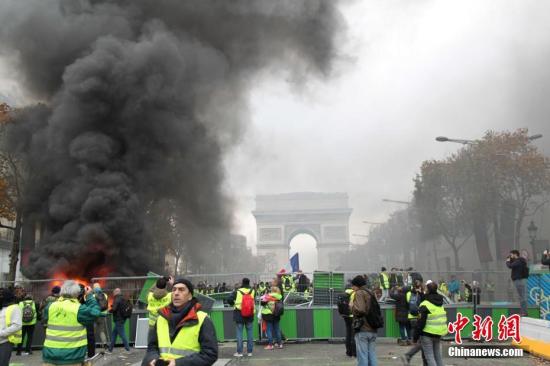 资料图：11月24日，巴黎香榭丽舍大街遭遇大规模示威活动。数以千计示威者聚集在街上，设置了不少路障，街道交通完全陷入瘫痪。