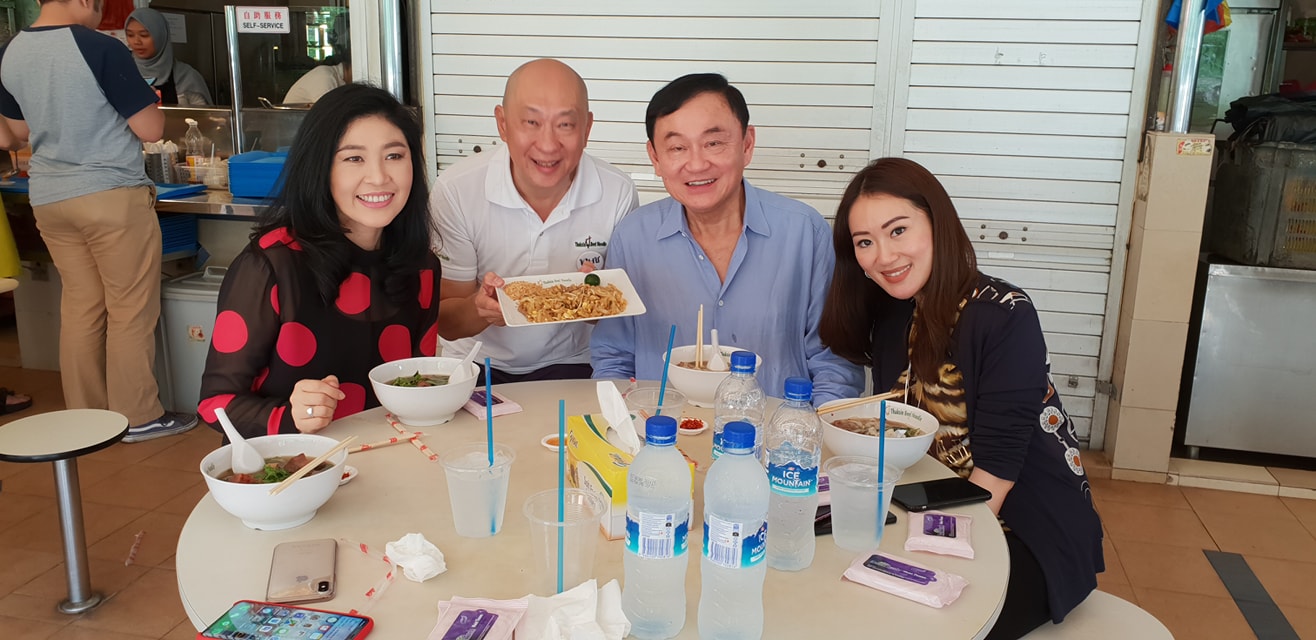 英拉、他信现身新加坡,去了一家名为他信牛肉面的餐馆。(Channel NewsAsia) 海外网12月20日电 流亡海外的泰国前总理他信、英拉兄妹每每现身,都会引发外界的关注。近日,二人被曝现身新加坡,并且去了一家名为他信牛肉面的餐馆。 据新加坡亚洲新闻频道(Channel NewsAsia)报道,当地时间周二(18日)中午,英拉、他信以及他信的女儿来到新加坡声音美食中心(Seah Im Food Centre),他们去了一家以他信名字命名的牛肉面馆就餐,并和面馆老板合影留念。 面馆老板说,他们