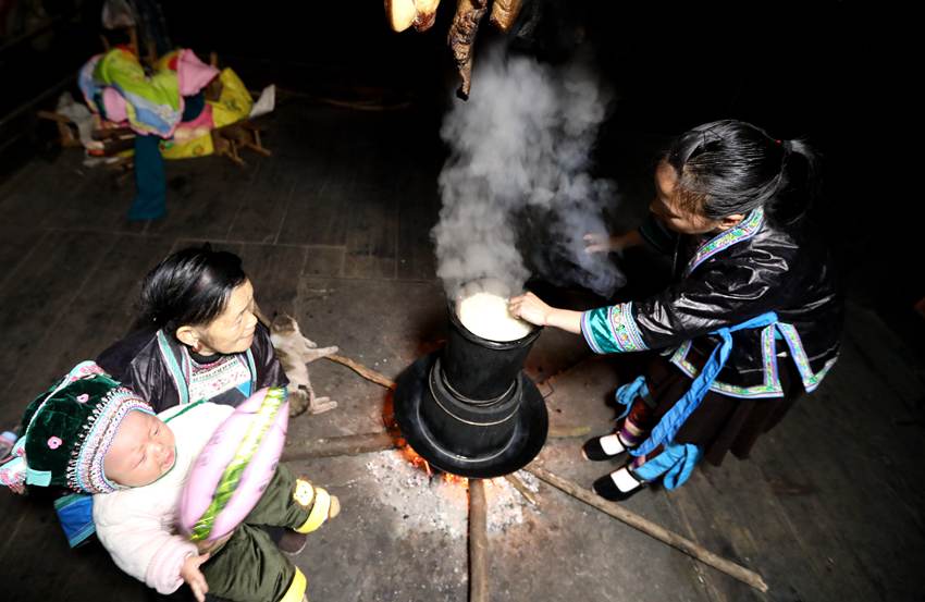 10  3月1日，位于桂黔交界的广西融水苗族自治县杆洞乡尧告苗寨，苗族女青年梁妤在家中用从碾米房碾好的糯米蒸糯米饭。_副本.jpg