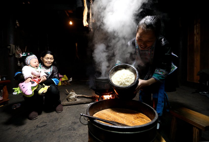 11  3月1日，位于桂黔交界的广西融水苗族自治县杆洞乡尧告苗寨，苗族女青年梁妤在家中把蒸好的糯米饭倒出准备午餐。_副本.jpg
