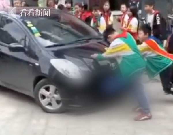 经过学校不顾阻拦 轿车顶着小学生强行通过
