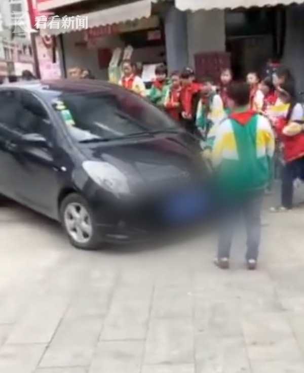 经过学校不顾阻拦 轿车顶着小学生强行通过