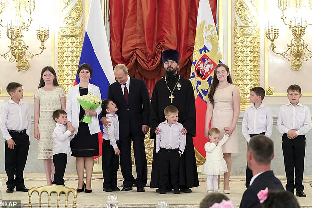 普京与多个俄罗斯家庭合影 孩子们的表情亮了(图)