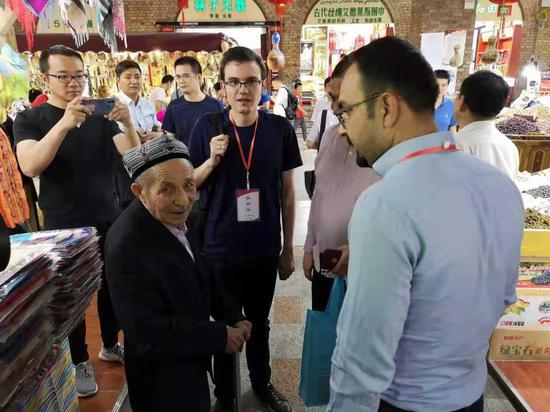 土耳其《星报》的国际新闻编辑赛里夫·阿赫麦特（中间位置穿黑T 恤、戴眼镜者）在新疆采访。