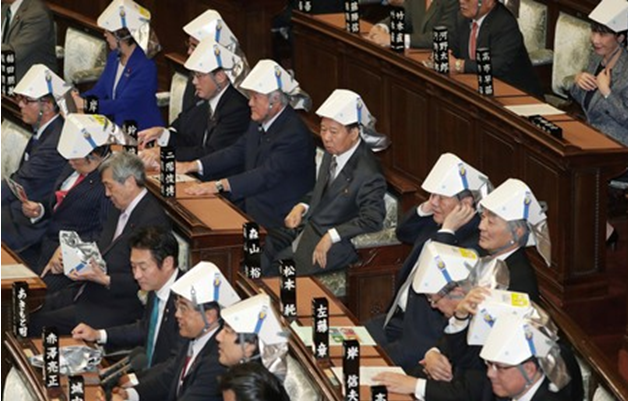 日本议员开会集体练习"戴安全帽" 现场笑声不断