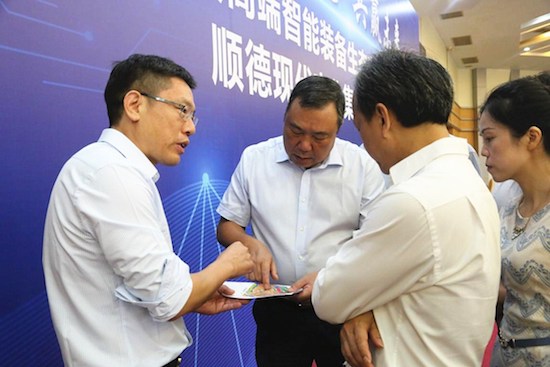 龙江镇党委书记何春云向领导介绍项目落地情况