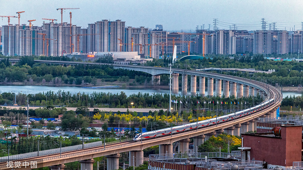 北京：火车蜿蜒穿行城市建筑