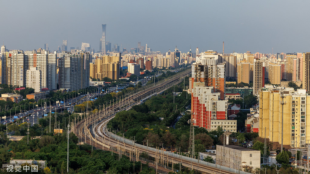 北京：火车蜿蜒穿行城市建筑