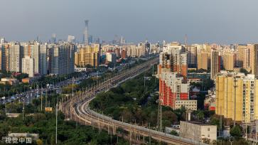 北京：火车蜿蜒穿行城市建筑