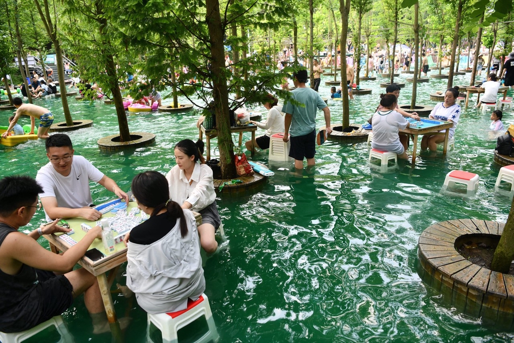 炎炎夏日 成都游客边泡脚边打“水上麻将”