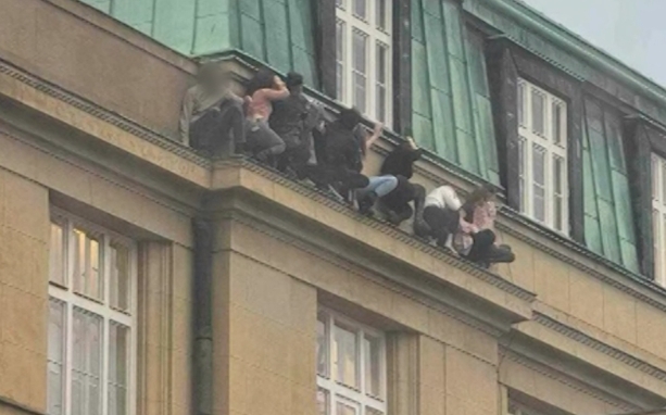 捷克首都布拉格一所大学的学生们躲在大楼窗台上躲避枪手。（社交媒体图片）