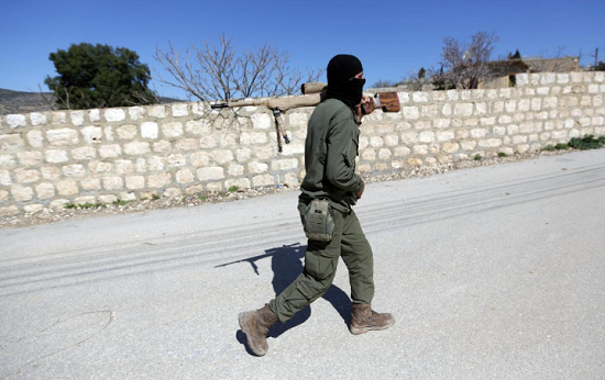 一名土耳其支持的叙利亚自由军战士在叙利亚阿夫林地区持武器向北行进