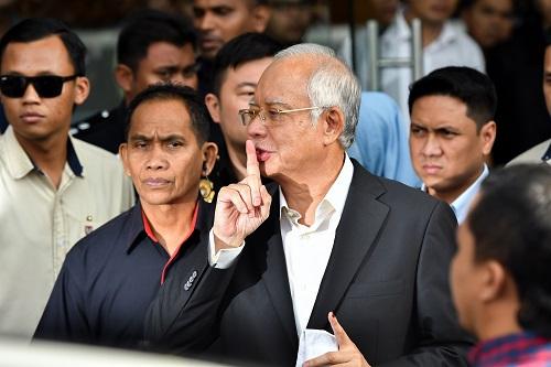 2018年5月24日，在马来西亚普特拉贾亚，马来西亚前总理纳吉布（前中）接受问话后离开反腐败委员会。 
