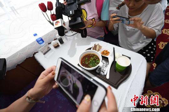 图为旅客拍摄列车上的牛肉面留念。　杨艳敏 摄