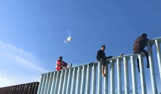 首批中美洲移民在美墨边境爬围栏