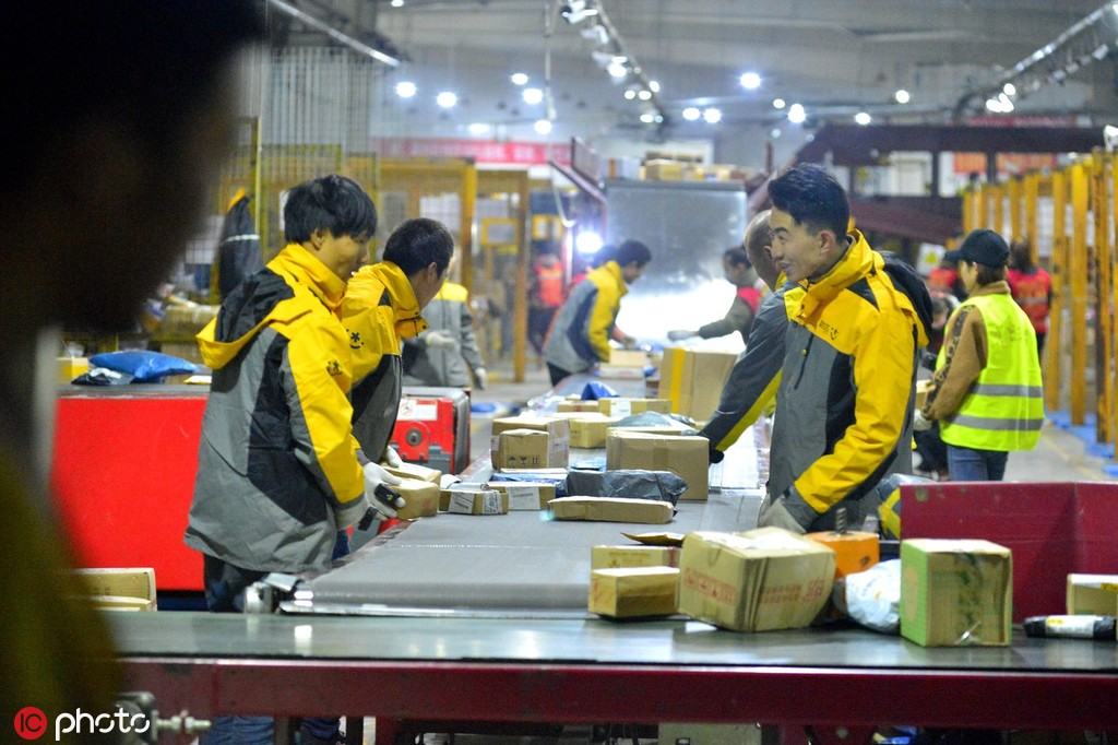 资料图:兰州市一家快递公司分拣中心工作人员正在忙碌着分拣堆积如山