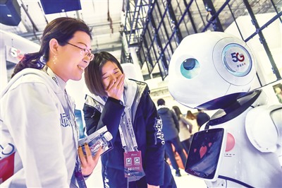 11月21日，在2019世界5G大会上，参观者在与一款5G机器人互动。新华社发（彭子洋摄）
