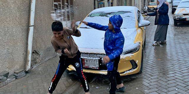 伊拉克儿童在巴格达的雪地里玩耍。（图源：美联社）