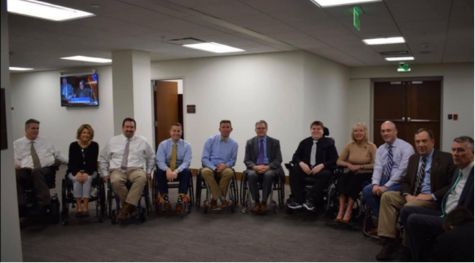 亚里克斯·约翰逊（右起第五位）和坐轮椅上班的议员们 （图源：CBS）