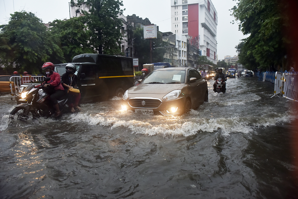 印度加尔各答暴雨天气致路面积水严重市民趟水出行