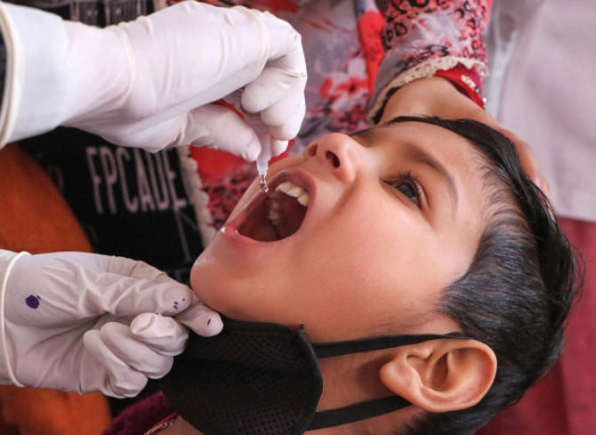 医护人员在为一名儿童滴服脊髓灰质炎疫苗。图源：印度报业托拉斯（PTI）