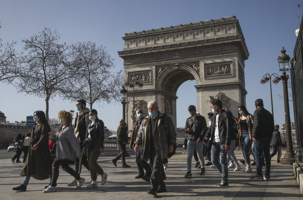 巴黎民众戴着口罩在香榭丽舍大街行走。