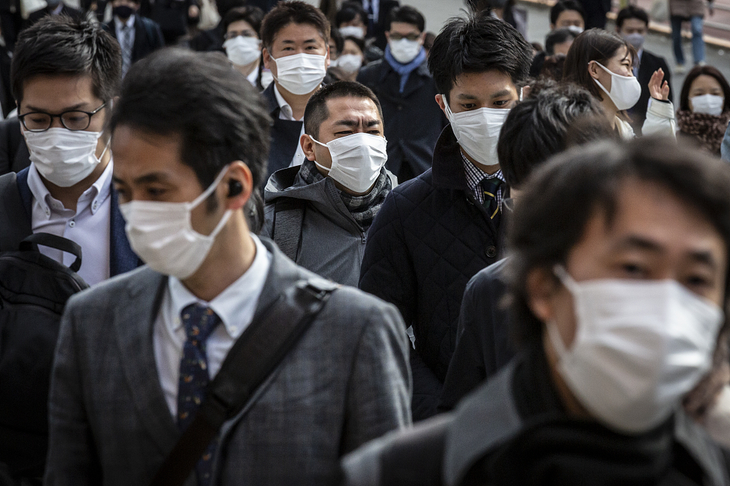 资料图：日本市民佩戴口罩出行