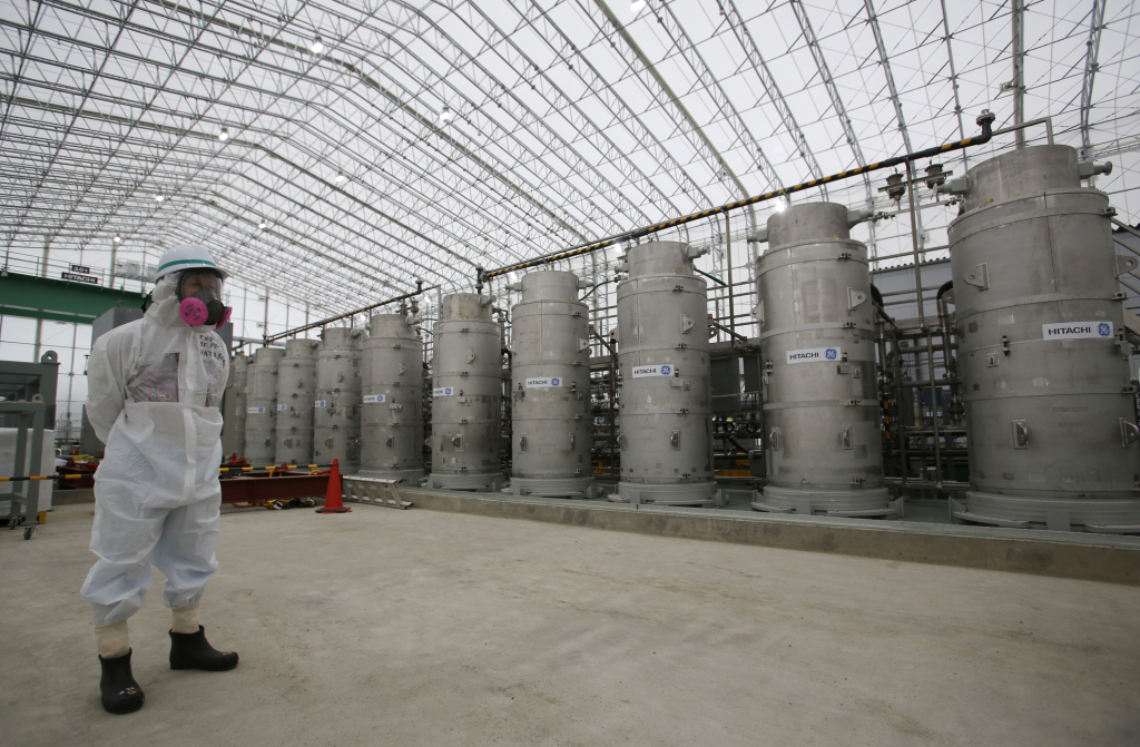2014年11月12日，身穿防护装备的官员站在福岛第一核电站液体处理系统前