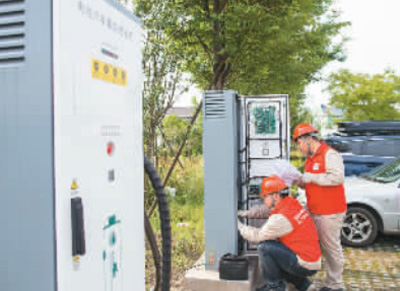 在江苏省海安市曲塘镇一国网充电点，技术人员对新装的充电桩进行调试。翟慧勇摄（人民图片）