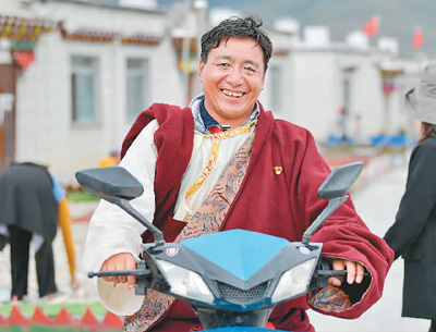 西藏自治区拉萨市当雄县羊八井镇彩渠塘村村民永央骑电动车出行。 新华社记者  张汝锋摄