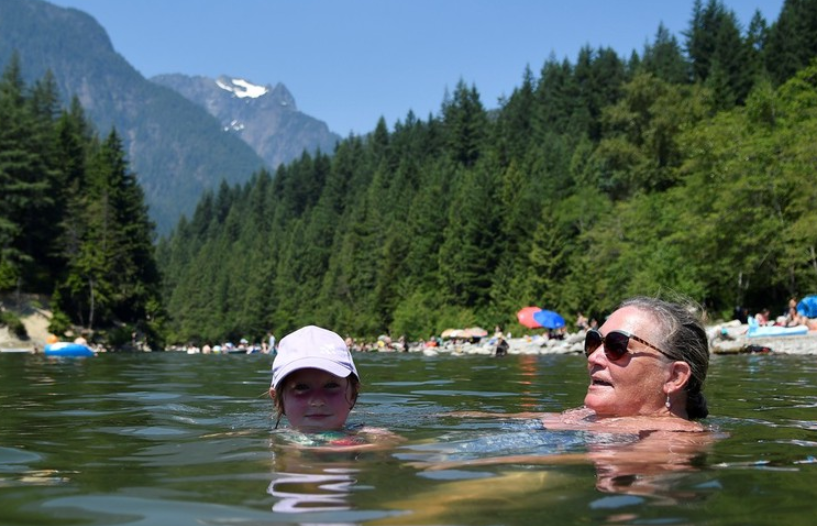 加拿大不列颠哥伦比亚省迎来高温，民众在湖中消暑。