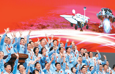航天科研人员在北京航天飞行控制中心指挥大厅庆祝我国首次火星探测任务着陆火星成功。新华社发