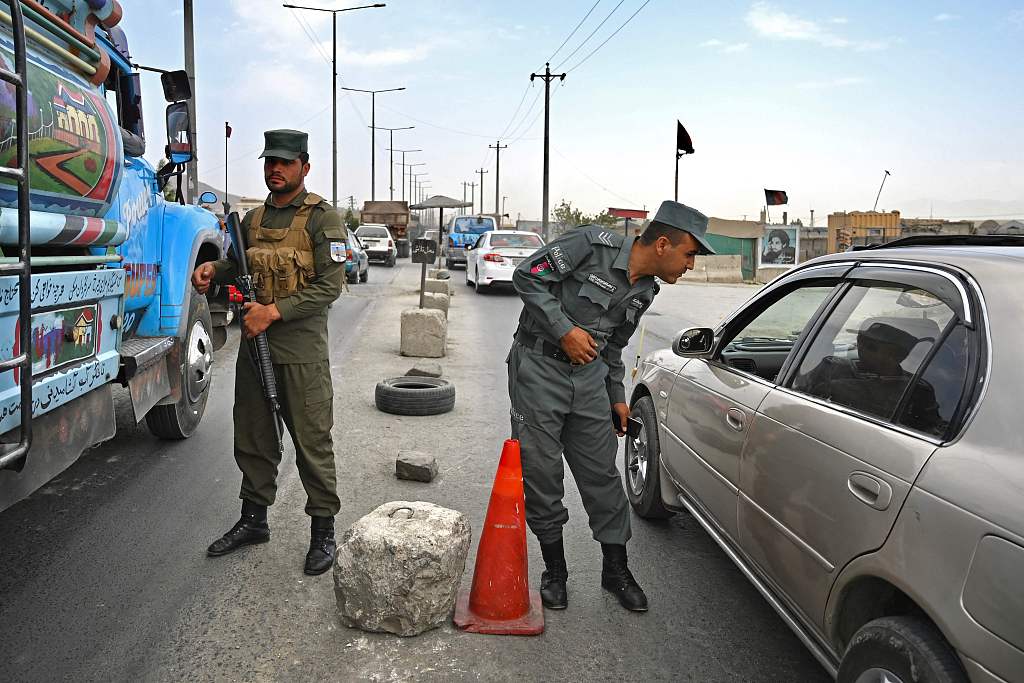 当地时间14日，阿富汗警察在首都喀布尔路边的一个检查站站岗。