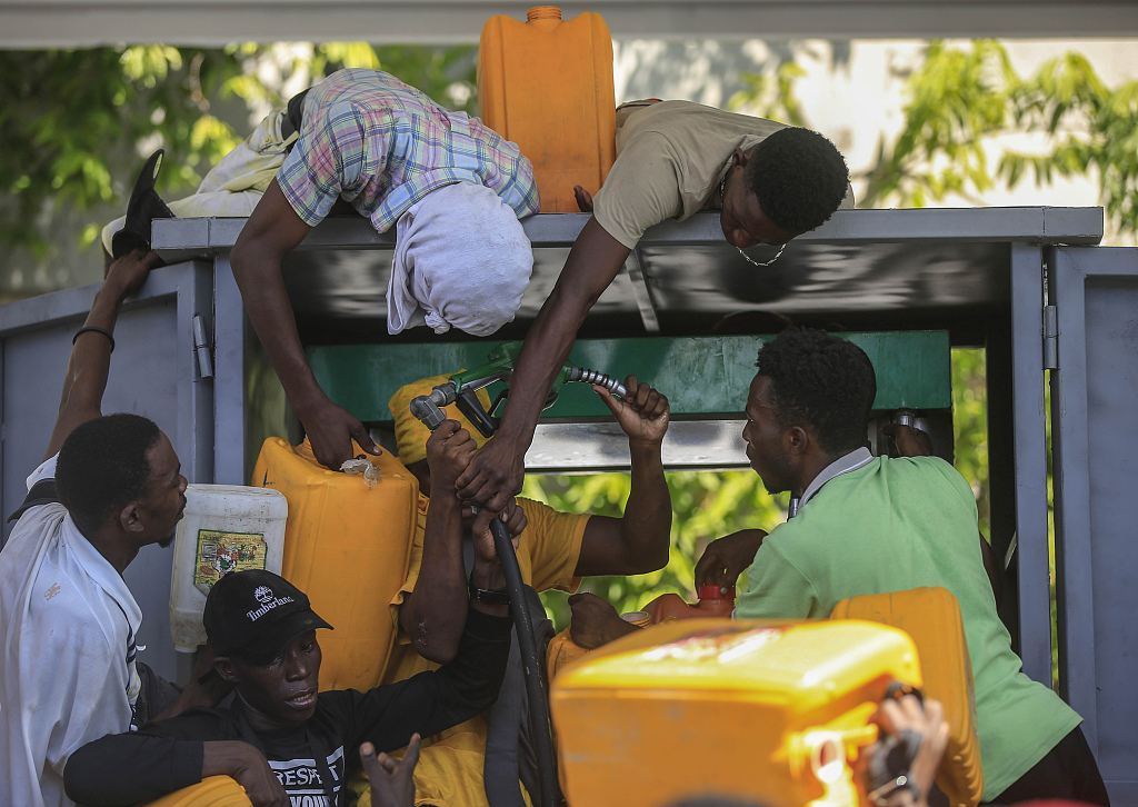资料图：海地首都太子港民众在加油站哄抢燃油。