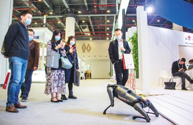 11月20日，参观者在“5G+工业互联网成果展”现场与仿真机器狗互动。伍志尊摄（新华社发）