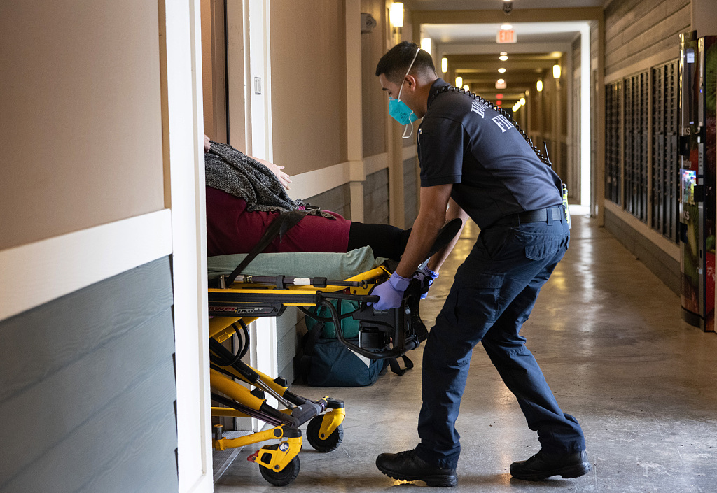 图为一名呼吸困难的病人被送进休斯敦一家医院。