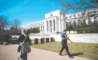 图为3月16日，在美国首都华盛顿，人们从美联储大楼前走过。沈 霆摄（新华社发）