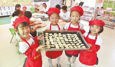 西陌中心园的孩子们展示和老师们一起包的饺子。肖永杰摄（人民视觉）