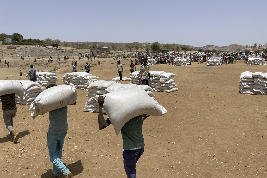 6月23日，埃塞俄比亚食品分发点，工作人员搬运小麦。