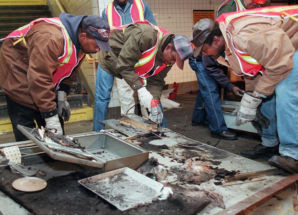 1995年11月26日，案发现场，工作人员拆除烧焦的投币机。（图源：美媒）