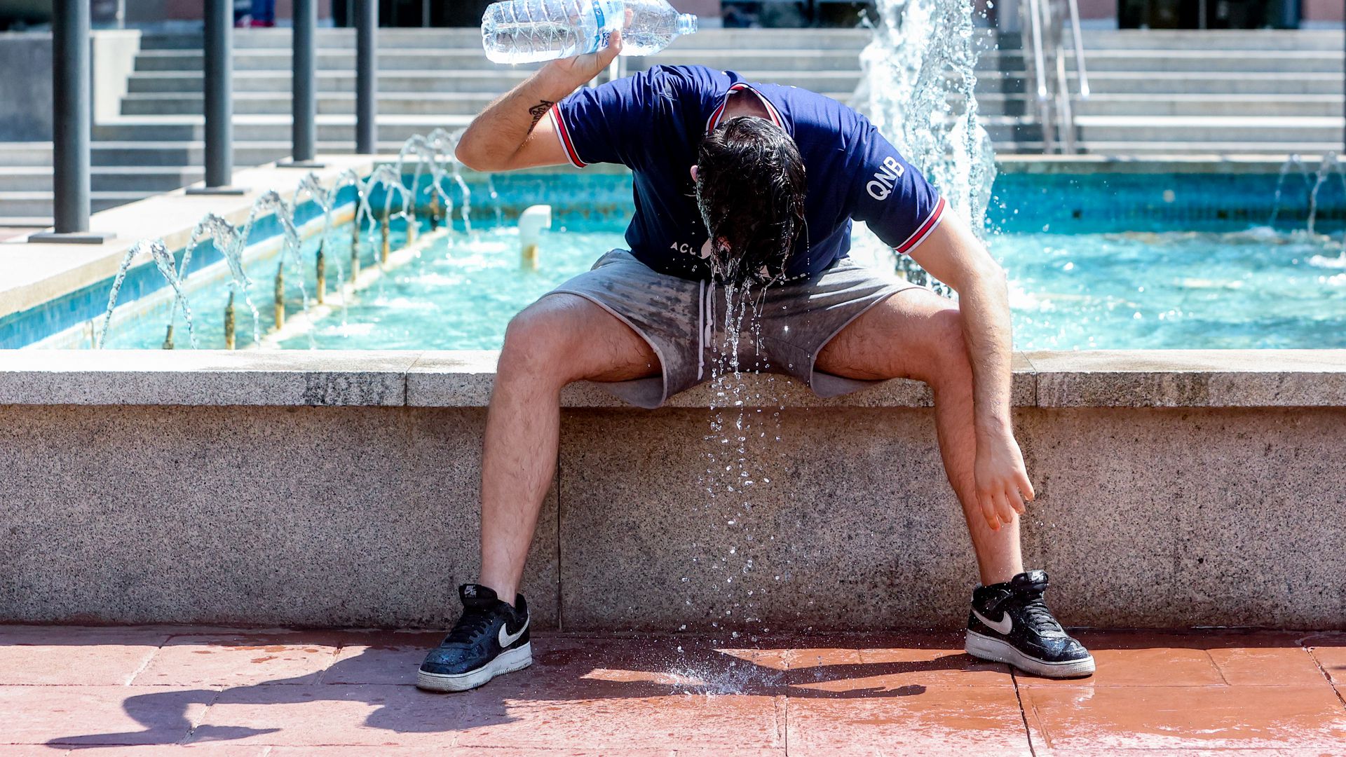 7月12日，西班牙马德里，一年轻男子往自己身上浇水降温。（资料图）