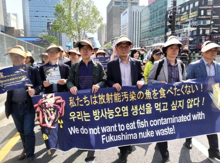 韩国市民团体手举“我们不想吃福岛核辐射鱼”的横幅在街头游行（社交媒体截图）