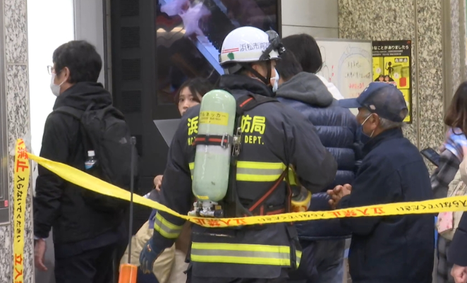 浜松站内，消防员安排乘客离开事发现场（静冈朝日电视台）